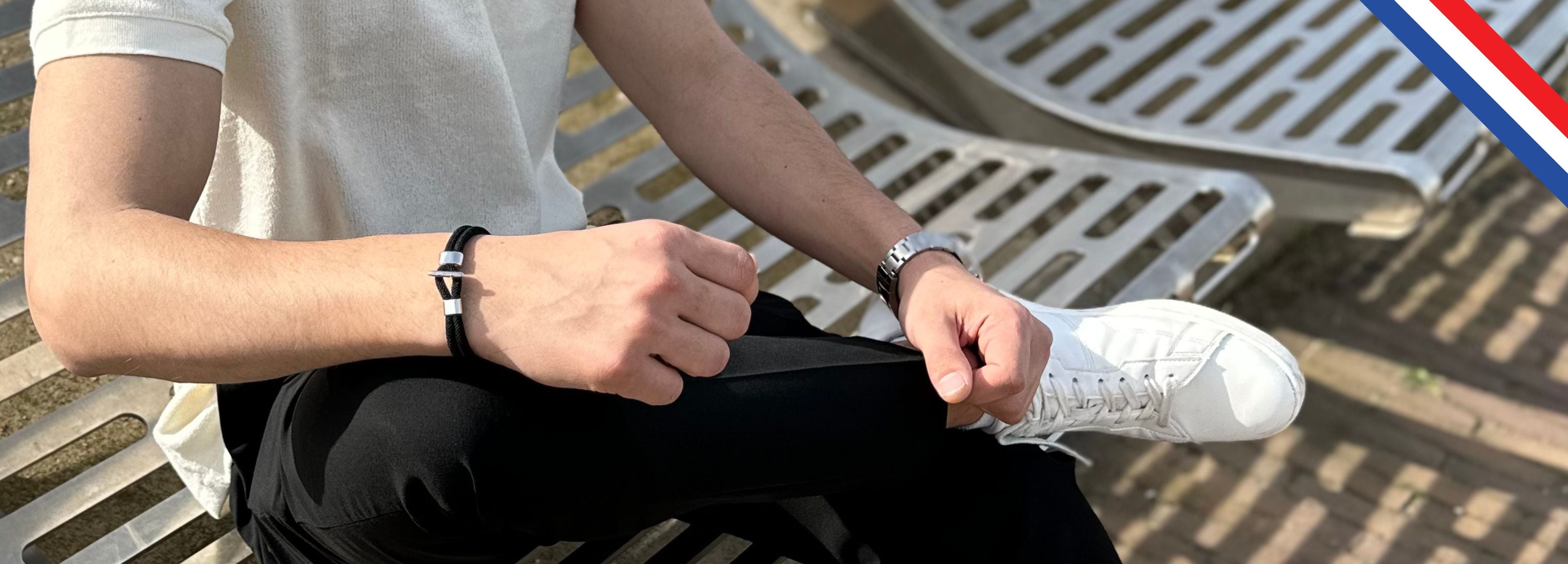 Zittende man, zwarte armband, frisse uitstraling met zwarte armband